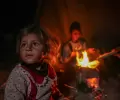 أطفال يتجمعون حول النار وسط البرد القارس في خيام النازحين بخانيونس وسط قطاع غزة