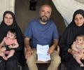 حمد العيسوي يتوسط ابنتيه اللتين فقدتا زوجيهما شهيدين