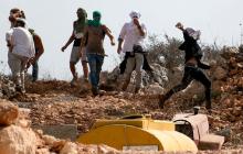 مستوطنون خلال هجوم على إحدى القرى الفلسطينية في مدينة نابلس