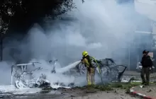 محاولة إخماد حريق اندلع في موقع سقوط شظايا صاروخ إيراني في "تل أبيب"