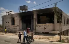 أطفال يقفون خارج مسجد أُحرق خلال هجوم شنه مستوطنون إسرائيليون في قرية قصرة بالضفة الغربية الأحد الماضي