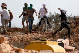 مستوطنون خلال هجوم على إحدى القرى الفلسطينية في مدينة نابلس