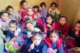 في هذه المساحة الضيّقة من منزلٍ تضرّر بالقصف في مخيم الشاطئ، صنعت المعلمة منى السيسي روضةً بديلة