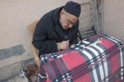 يجلس أبو تامر علي متكئًا على “الووكر” يراقب خطواته القليلة كما لو كانت إنجازًا يوميًا شاقًا