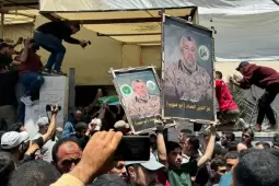 مواطنون يرفعون صورا للقائد الشهيد عز الدين الحداد
