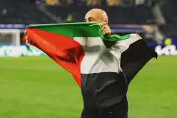 مدرب المنتخب المصري حسام حسن يرفع العلم الفلسطيني بعد فوزه على أستراليا في كأس العالم