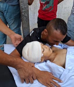 والد الطفل الشهيد عبد الرحمن بدوان يحضن جثمان نجله بعد استشهاده في حي الزيتون برصاص رشّاش آلي إسرائيلي مثبّت على رافعة شرقي مدينة غزة