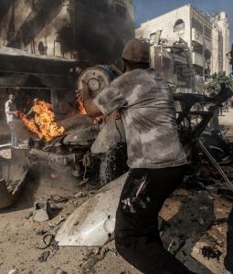 فلسطينيون يحاولون إخماد حريق في مركبة دمرتها غارة جوية إسرائيلية جنوب مدينة غزة، 22 أكتوبر/تشرين الأول