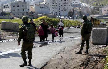 مواطنون يسيرون على إحدى حواجز الاحتلال