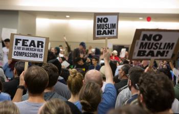 محتجون في أحد المطارات الأميركية على قرار ترامب بمنع سفر المسلمين إلى بلادهم - (أ ف ب)