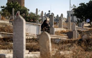 امرأة فلسطينية تزور المقبرة صبيحة العيد بغزة (الأناضول)