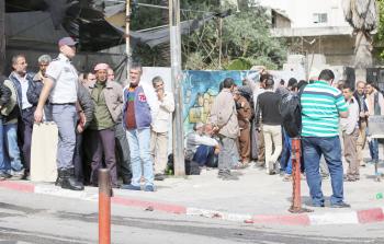 مواطنون بانتظار استلام شيك المساعدات الاجتماعية بغزة أمام أحد البنوك