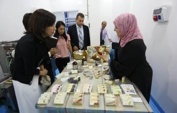 صوالحة (يميناً) تشرح عن منتجاتها لأحد الوفود الأجنبية (الأناضول)