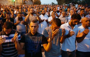 فلسطينيون يؤدون الصلاة أمام الأقصى احتجاجاً على البوابات الالكترونية (أ ف ب)