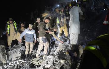 جانب من البحث عن ضحايا الطائرة الباكستانية (أ ف ب)