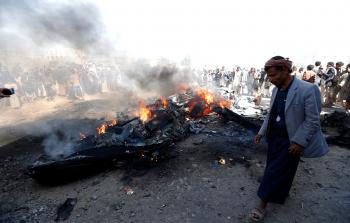 يمنيون يتجمعون حول حطام طائرة بدون طيار للتحالف العربي (أ ف ب)