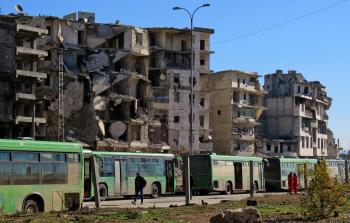 حافلات تستعد لنقل مقاتلي المعارضة وعائلاتهم من شرقي حلب  (أ ف ب)