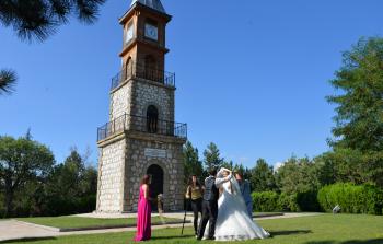 عروسان تركيان يلتقطان صور زفافهما بجانب ساعة 