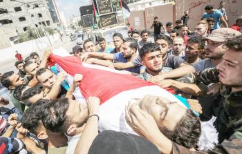 مواطنون يشيعون جثمان الشهيد محمد بدوان بغزة أمس (الأناضول)