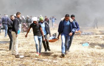 شبان ينقلون أحد المصابين شرق خانيونس (تصوير / ياسر فتحي )