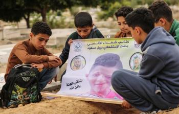 أطفال يزورون قبر صديقهم الذي قتله قناص الاحتلال (أرشيف)