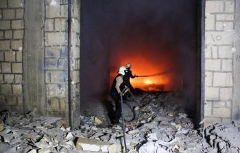 متطوعو الدفاع المدني يحاولون السيطرة على الحريق الذي اندلع في سجن في إدلب السورية (أ ف ب)