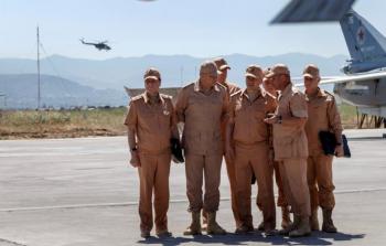 وزير الدفاع الروسي سيرغي شويغو يتوسط عددا من الجنود في قاعدة حميميم (رويترز)