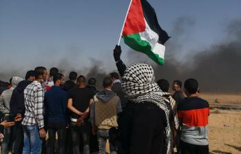 فلسطينية ترفع علم فلسطين شرق رفح أثناء مشاركتها بمسيرة العودة الكبرى (تصوير/ ربيع أبو نقيرة)