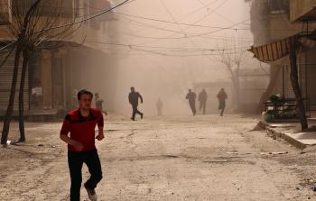 سوريون يفرون إثر قصف جوي في الغوطة الشرقية (أ ف ب)