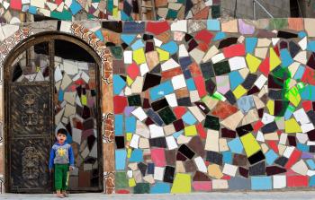 طفل فلسطيني يقف امام منزله بعد صيانته من ركام المنازل المجاورة في حي الشجاعية نتيجة الحرب الاخيرة2014 (ياسر قديح)