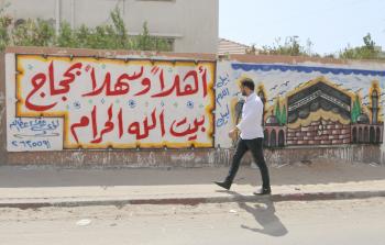 مواطن يمر من أمام إحدى الجداريات في غزة (تصوير / محمود أبو حصيرة)