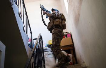 جندي من القوات العراقية الخاصة يفتش منزلاً في الموصل (أ ف ب)