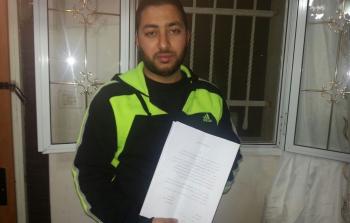 صورة أرشيفية لمقدسي يستعرض قرار منع سفر سلمته إياه قوات الاحتلال 