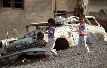 طفل يلعب بجوار سيارة محطمة في اليمن تصوير - (أ ف ب)