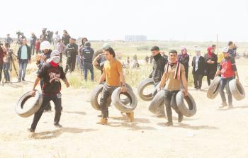 شبان ينقلون الكوشوك خلال مشاركتهم في مسيرة العودة شمال القطاع 