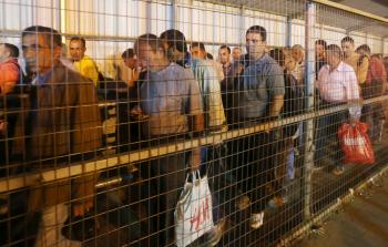 صورة أرشيفية لعمال فلسطينيين أثناء محاولتهم اجتياز حاجز إسرائيلي