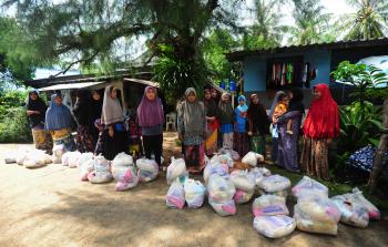 نساء تايلانديات متضررات من الفيضانات يستلمن مساعدات غذائية (أ ف ب)