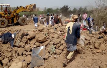 يمنيون يزيلون آثار غارة للتحالف العربي (أ ف ب)