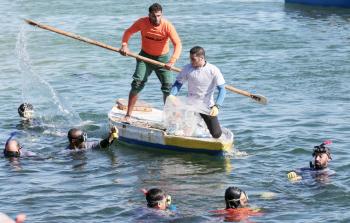 غواصون ينظفون ميناء غزة من القاذورات أمس/تصوير ياسرفتحي