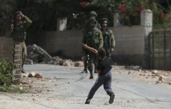 طفل فلسطيني يقذف جنود الاحتلال بالحجارة (أ ف ب)