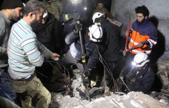 عمال إنقاذ سوريون يحاولون انتشال ضحايا تحت أنقاض مبنى دمره قصف النظام (أ ف ب)