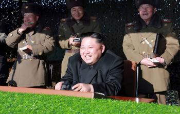 الزعيم الكوري الشمالي يضحك أثناء مشاهدته لعرض عسكري (أ ف ب)