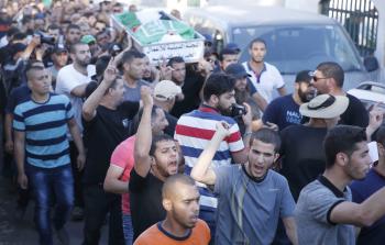 مواطنون يشيعون جثمان الشهيد محمد طه في كفر قاسم أمس (أ ف ب)