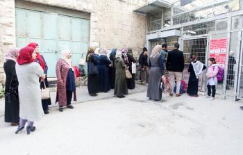 معلمو المدرسة وطلابها يقفون للسماح لهم بالوصول للمدرسة