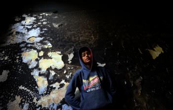 طفل  فلسطيني يقف داخل  منزل عائلة الهندي  الذي حرق بسبب اشتعال النيران فيه نتيجة انقطاع الكهربائي  (ياسر قديح)