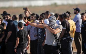 شاب فلسطيني يواجه قنايل الاحتلال بالحجر والمقلاع (أرشيف)