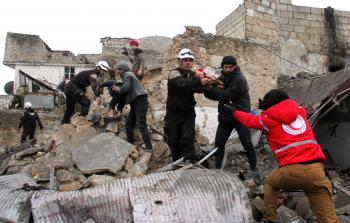 عمال إنقاذسوريون ينتشلون الضحايا إثر قصف جوي لمبنى سكني في إدلب (أ ف ب)