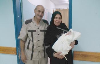 والدة الأسير إيهاب ابو نحل تحمل حفيدها سعد