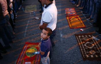 فلسطينيون يؤدون الصلاة أمام الأقصى احتجاجاً على البوابات الالكترونية (أ ف ب)