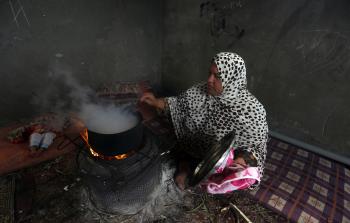 امراة فلسطينية تطهو على الحطب لاطفالها في منزلها  المتواضع في  احد الاحياء العشوائية في مدينة خان يونس جنوب قطاع غزة (ياسر قديح)